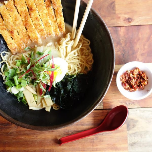 Kameya Ramen & Sushi's ramen bowl with tonkatsu, egg, seaweed, and vegetables, with chili paste.